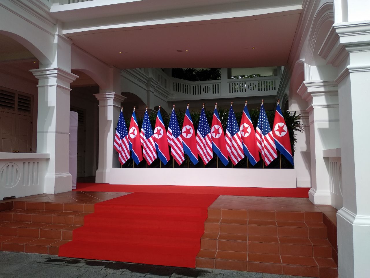 Cờ Mỹ và Triều Tiên tại khách sạn Capella, nơi sắp đón hai nhà lãnh đạo Mỹ-Triều dự hội nghị thượng đỉnh lịch sử. Tại đây, hai nhà lãnh đạo sẽ bắt tay.