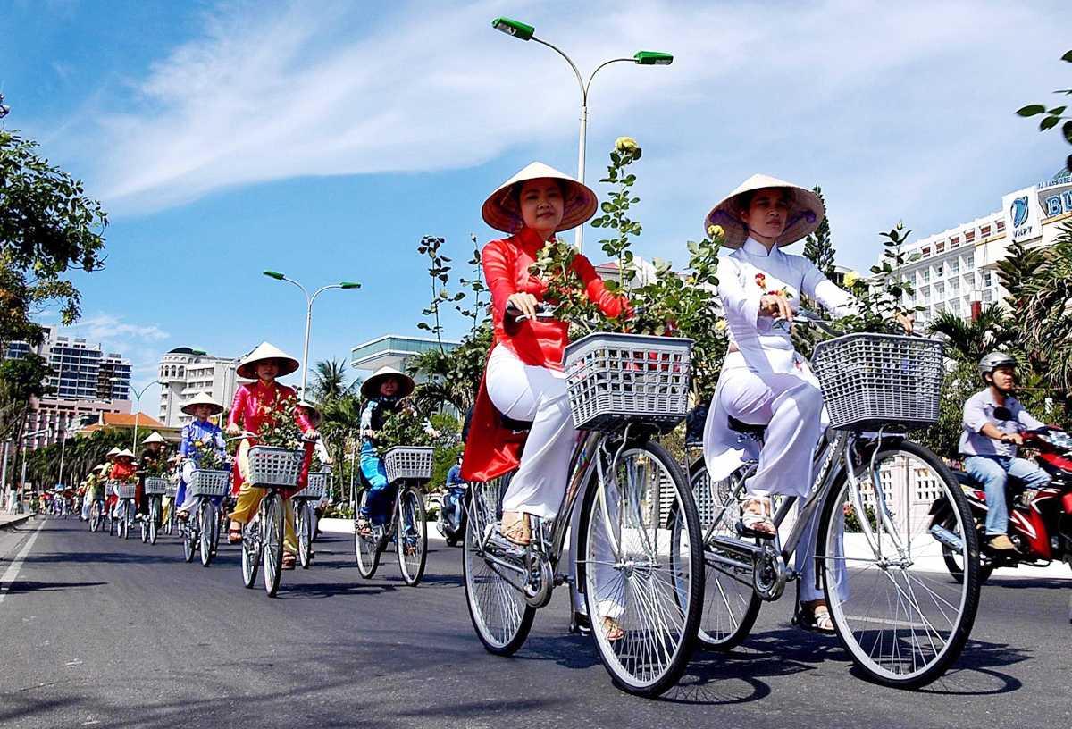 Thiếu nữ áo dài diễu hành xe đạp mang theo những bông hồng trên các tuyến phố chính của TP Nha Trang (Khánh Hòa) tại Festival Biển Nha Trang. Ảnh: Anh Tuấn/TTXVN