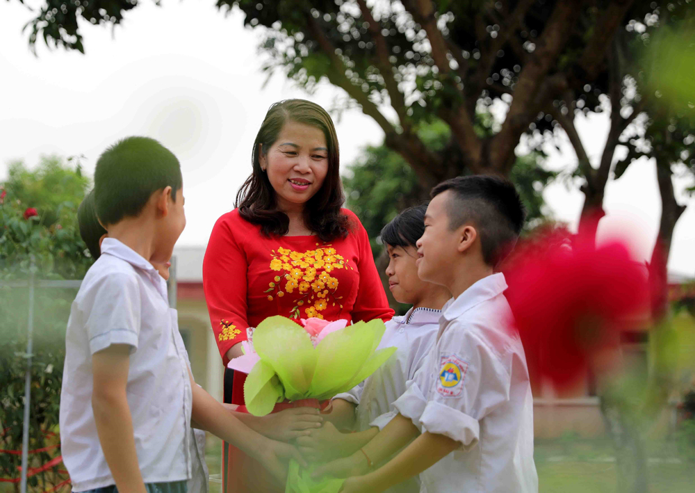 Với cô giáo Đinh Thị Thủy, người đang dành trọn tình thương cho lớp học của trẻ mồ côi, bị cha mẹ bỏ rơi, mang trong mình căn bệnh thế kỷ HIV/AIDS tại Trung tâm Chữa bệnh giáo dục lao động xã hội số 2 (xã Yên Bài, huyện Ba Vì, Hà Nội) thì việc mặc áo dài không chỉ đẹp cho mình mà còn khiến các con cảm thấy thêm tin yêu vào cuộc sống, vào những người xung quanh. Ảnh: Thanh Tùng/TTXVN