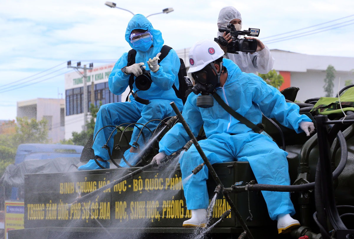 Phóng viên Chi nhánh Trung tâm Truyền hình Thông tấn tại Đà Nẵng tác nghiệp trên thùng xe đi phun thuốc khử trùng các khu vực có nguy cơ lây nhiễm COVID-19 cao trên địa bàn quận Sơn Trà (thành phố Đà Nẵng).