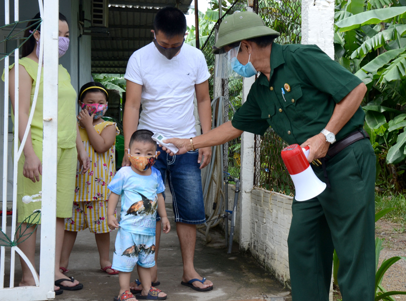 Cựu chiến binh Nguyễn Tiến Ca, Tổ trưởng Tổ dân phố 22 ,phường Hòa Phát, quận Cẩm Lệ, thành phố Đà Nẵng, kiểm tra thân nhiệt cho một hộ gia đình.