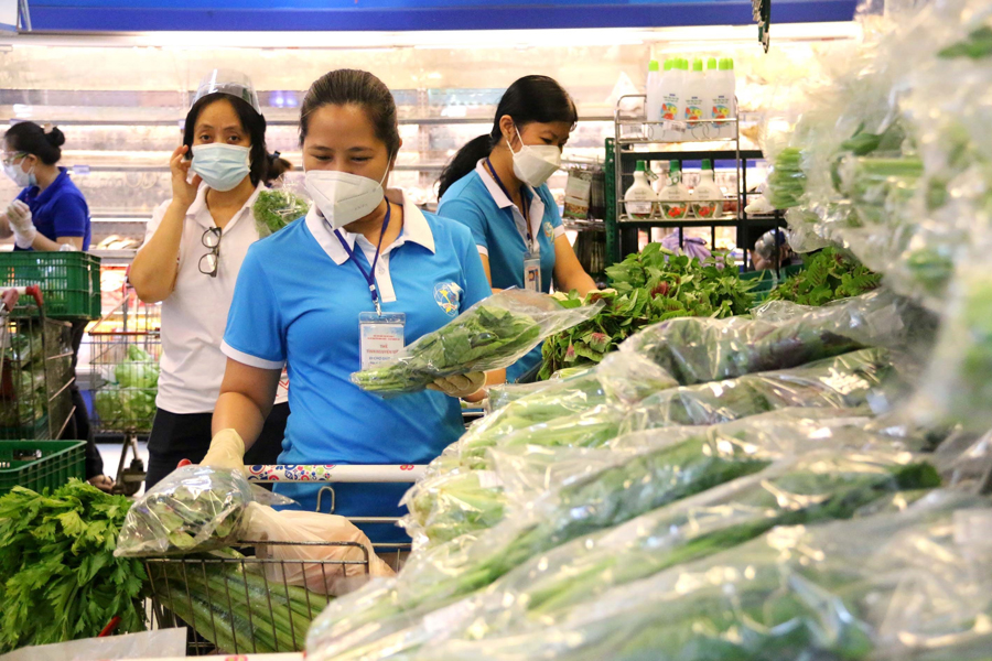 Hội viên Hội Liên hiệp phụ nữ Quận 3 đi chợ giúp dân mua hàng hóa, thực phẩm.