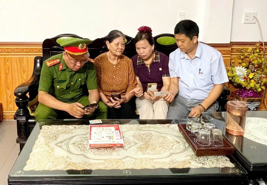 Bà Vũ Thị Thanh Thủy, Tổ trưởng Tổ dân phố 1, phường Hà Giang 1 (thứ hai từ phải sang), cùng lực lượng Công an và tổ công nghệ số cộng đồng hướng dẫn người dân sử dụng các tiện ích số trên điện thoại thông minh.