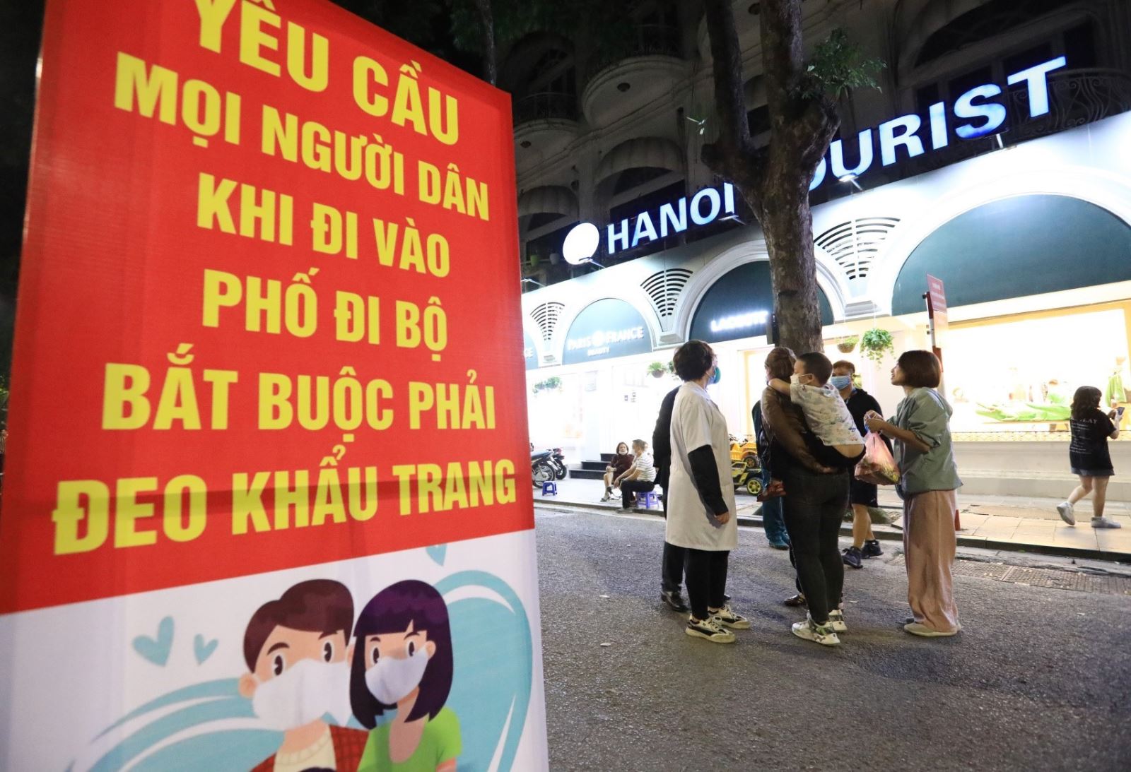 Tuyên truyền đeo khẩu trang phòng, chống dịch COVID-19 tại phố đi bộ Bờ Hồ thuộc quận Hoàn Kiếm (Hà Nội).