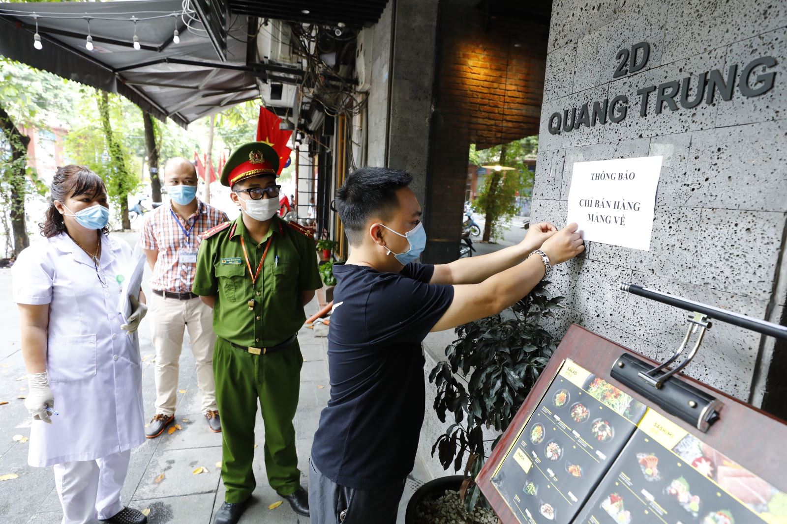 Các hộ kinh doanh ở Hà Nội dán thông báo chỉ bán hàng mang về ngoài cửa hàng nhằm phòng, chống dịch COVID-19.