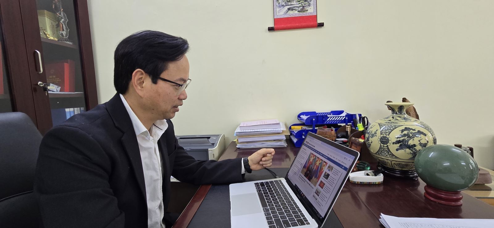 Tiến sĩ Nguyễn Đình Hoàng nghiên cứu thông tin về Đại hội Đại biểu toàn quốc lần thứ XIV của đảng trên website của Thông tấn xã Việt Nam.