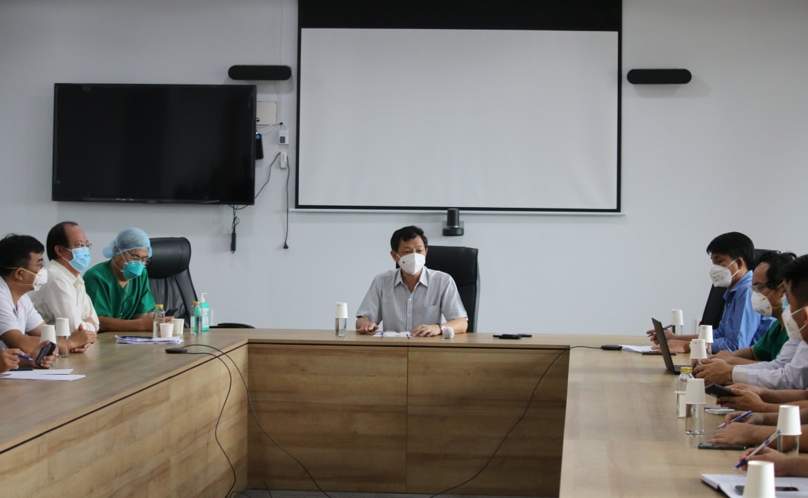 Bác sĩ Nguyễn Tri Thức (ở giữa) họp bàn các chiến lược chặn dịch từ xa tại Bệnh viện hồi sức COVID-19.
